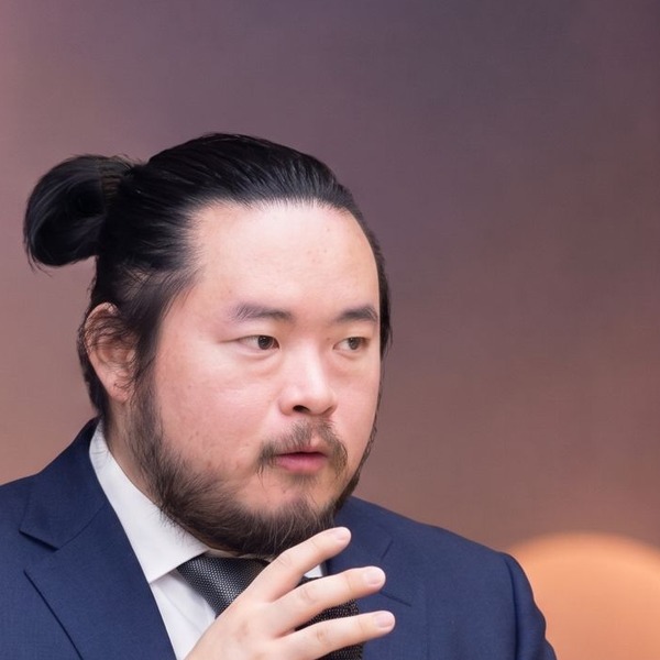Lok Wong headshot — speaking on stage.