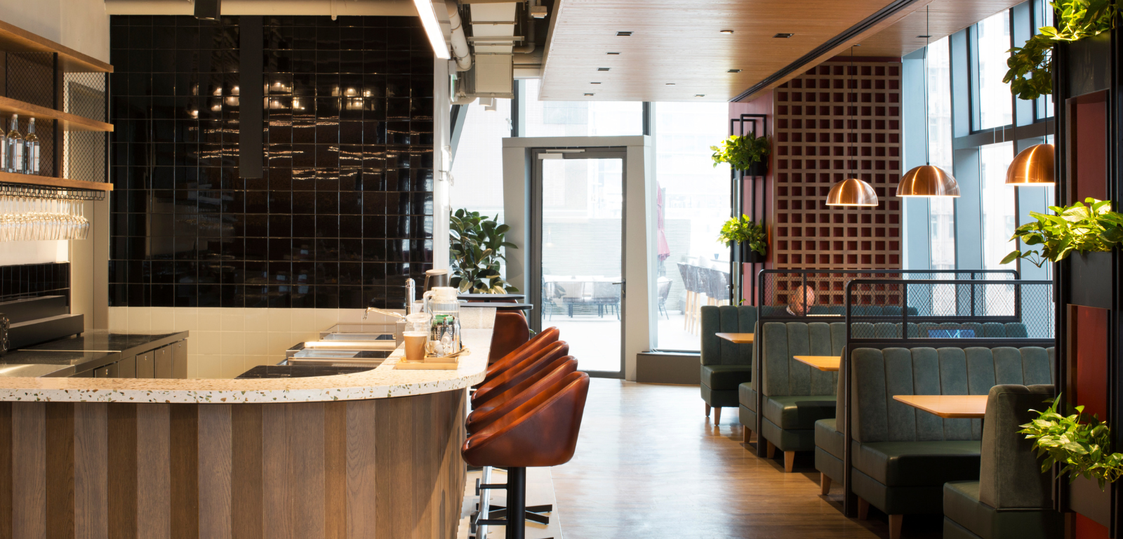 The Hive Causeway Bay — the bar and lounge area with copper pendant lights, banquette seating, and a long counter.