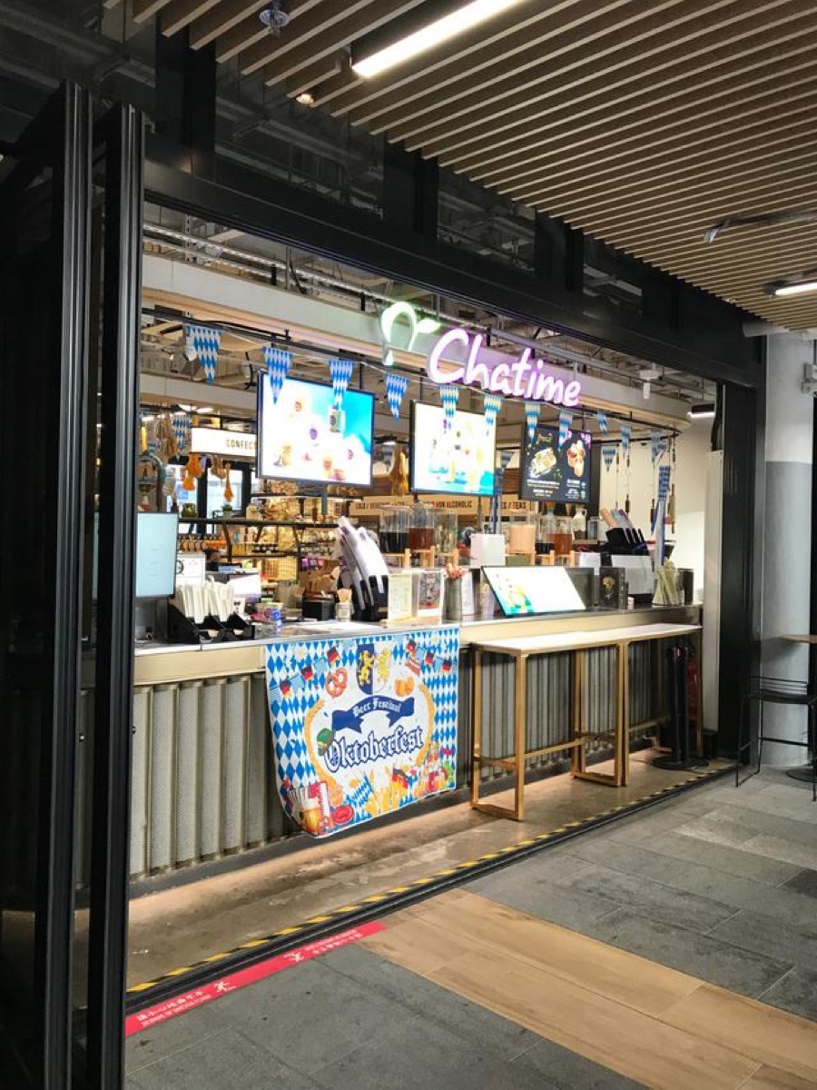 The Chatime storefront in Central Market — purple neon Chatime sign and an Oktoberfest banner on the counter.