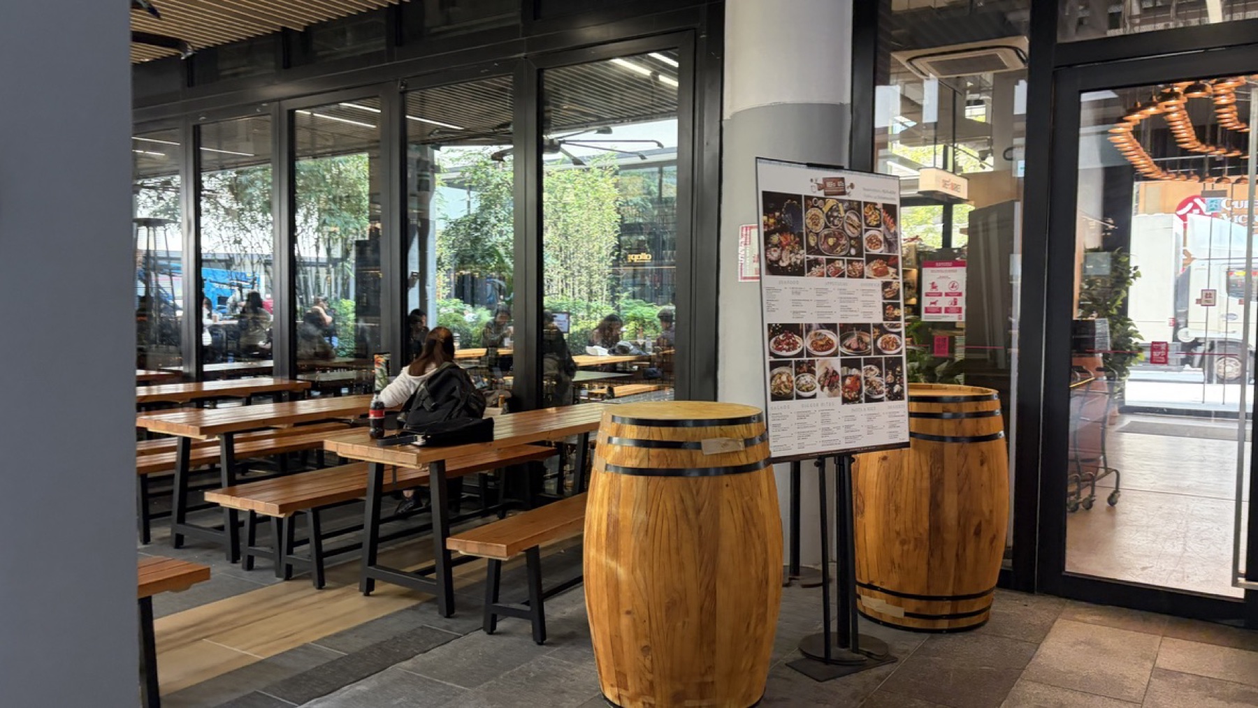 Empty wooden benches and barrel tables in the Central Market courtyard.