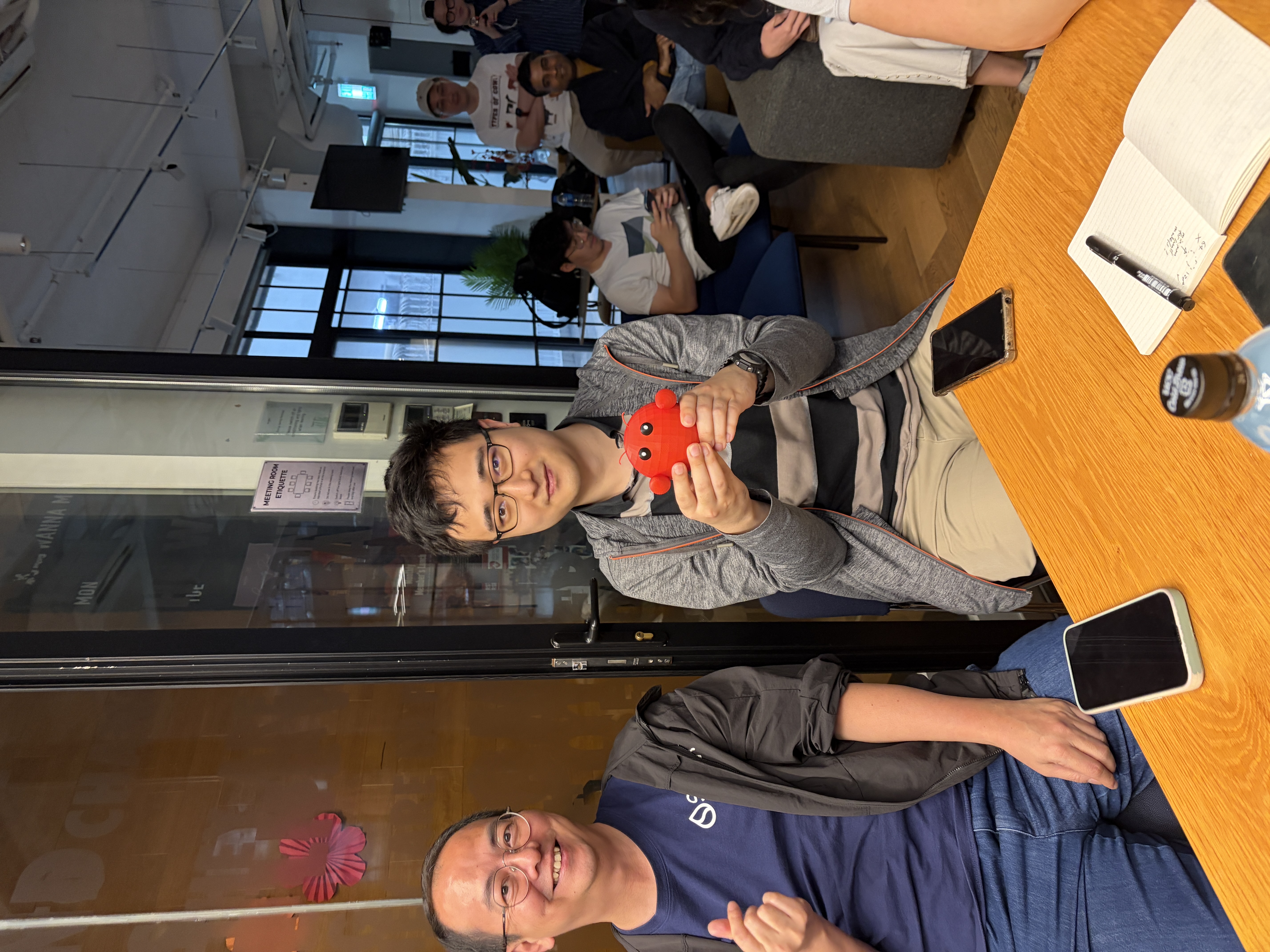 Morgan holding the 3D-printed OpenClaw mascot prize, with Hanley and the crowd behind