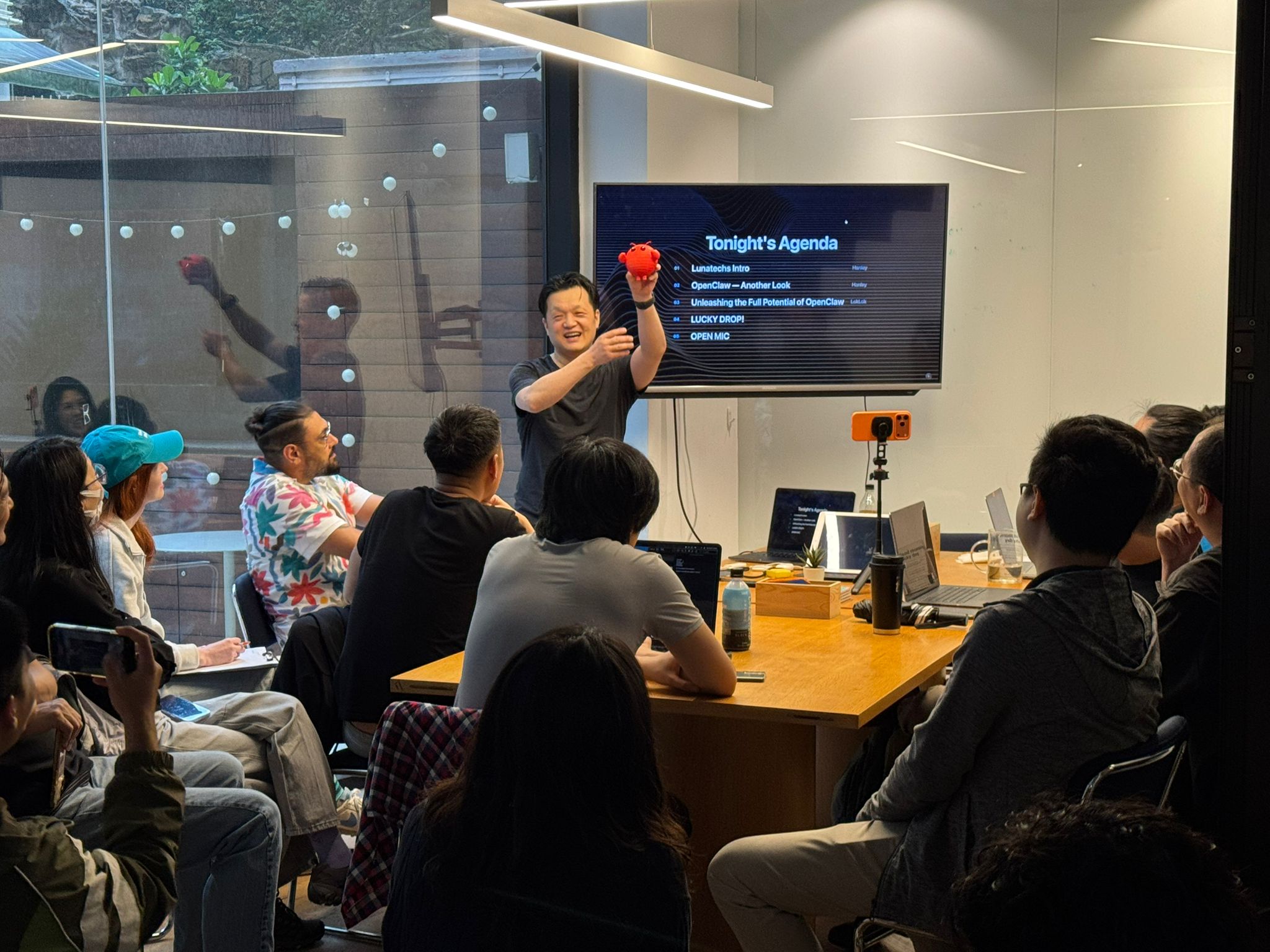 Hanley holding the OpenClaw mascot in front of a packed room at the Lunatechs CLAW BITES meetup