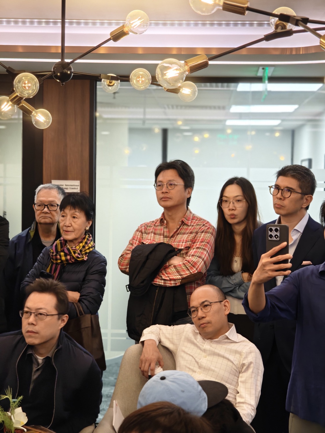 Attendees watching intently, phones recording