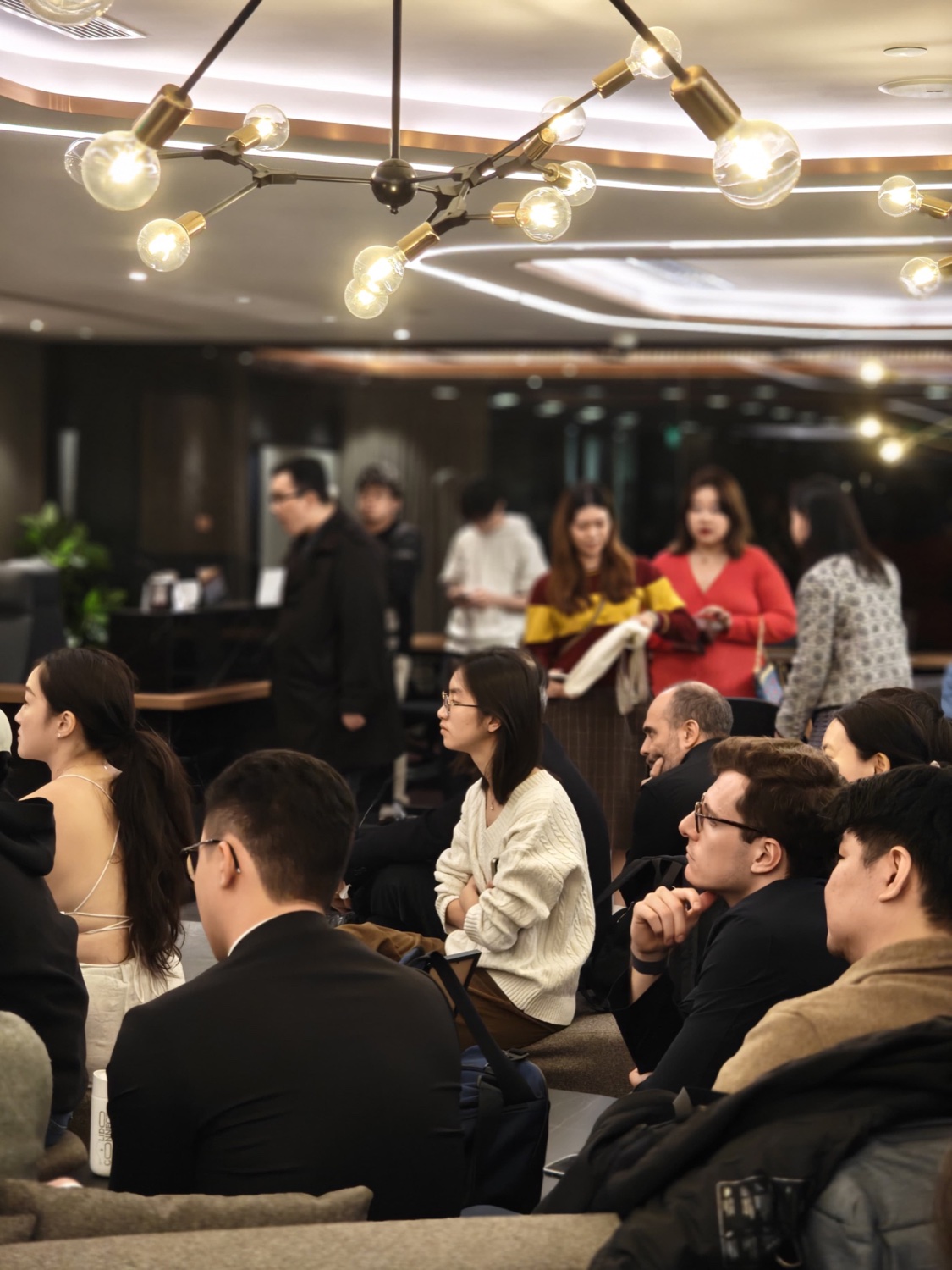 Engaged audience under chandelier lighting