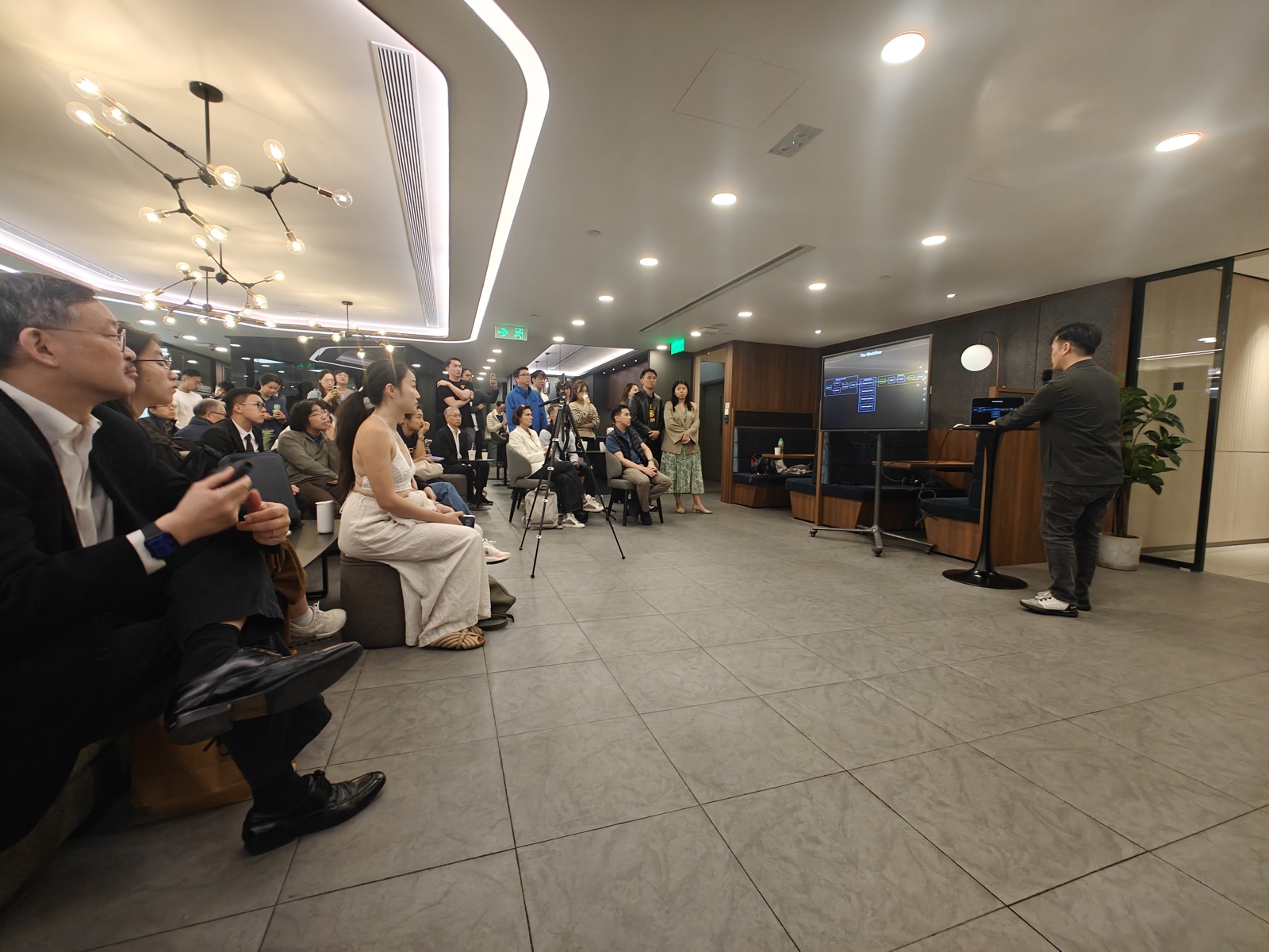 Speaker presenting to engaged audience with screen