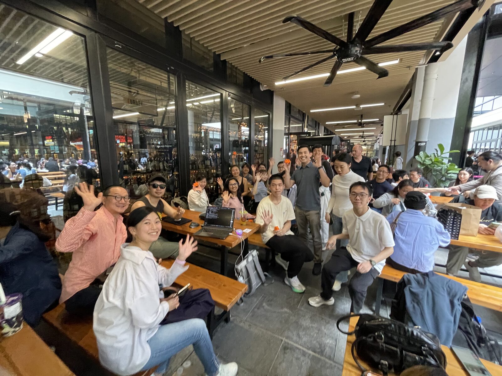 Lunatechs community gathered at the Central Market courtyard with laptops out, waving.