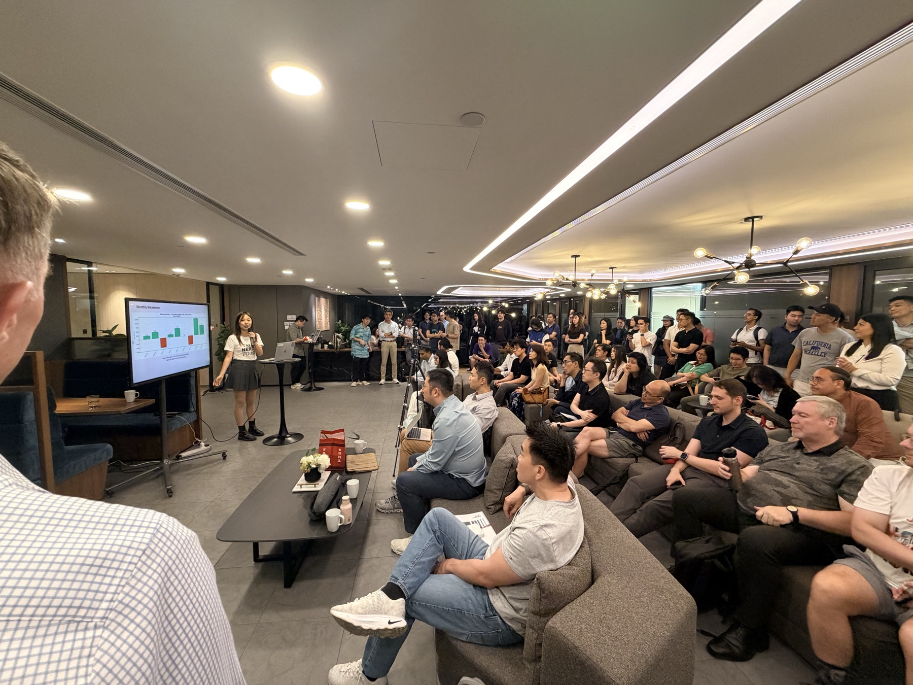Shally presenting from the podium to a full lounge
